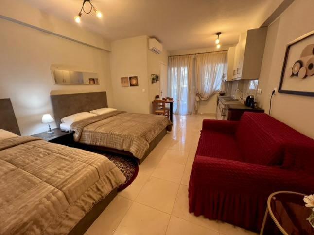 a hotel room with two beds and a red couch at Velvet studios Ioanna in Naousa