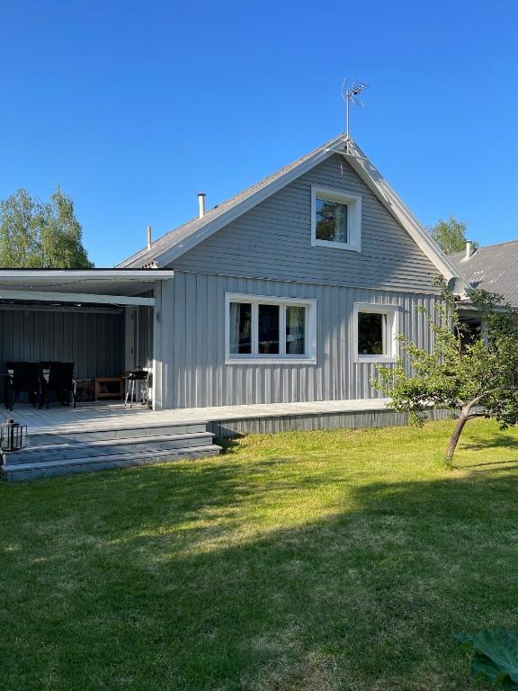 a gray house with a porch and a yard at Villa Daga in Vidsel