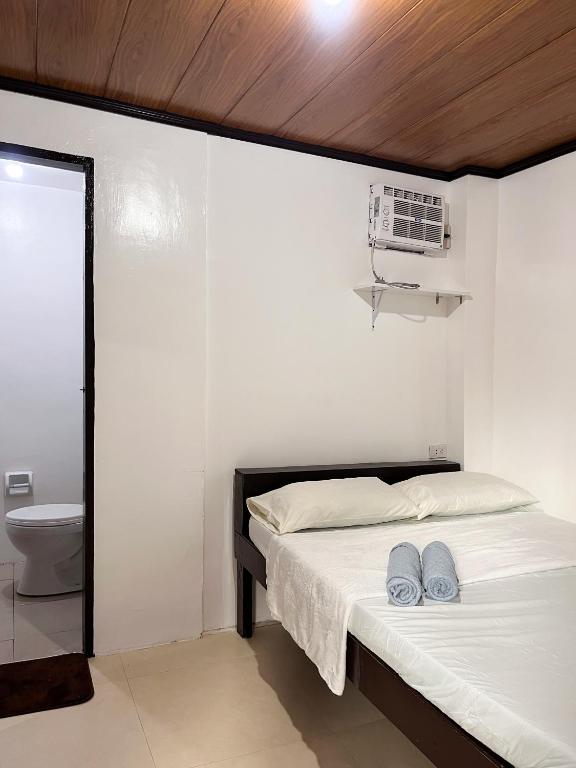 a bedroom with a bed with two blue slippers on it at Shiloh Homestay in General Luna