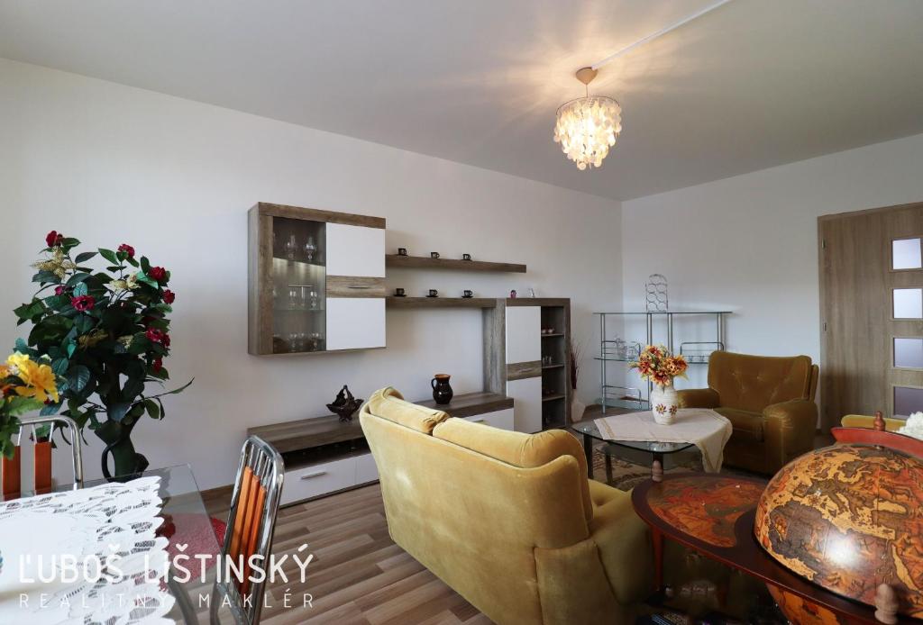 a living room with a couch and a table at Apartman Pod Vysokymi Tatrami in Nová Lesná