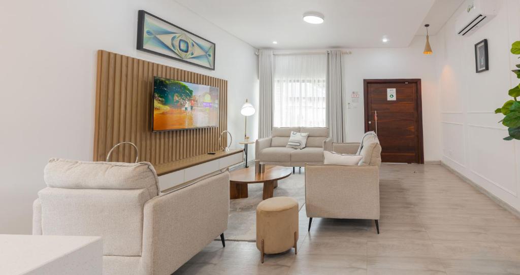 a living room with chairs and a couch and a table at Elle Apartments in Lusaka