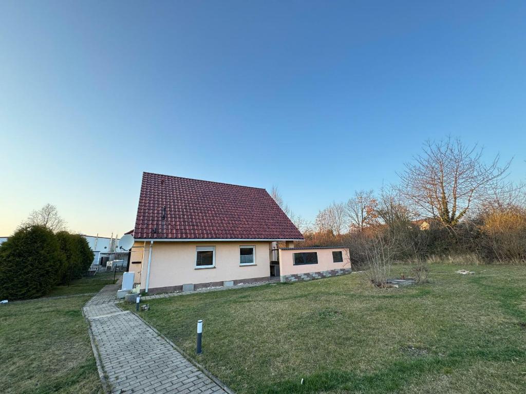 a small white house with a red roof at Asiatisches Ferienhaus in Merseburg