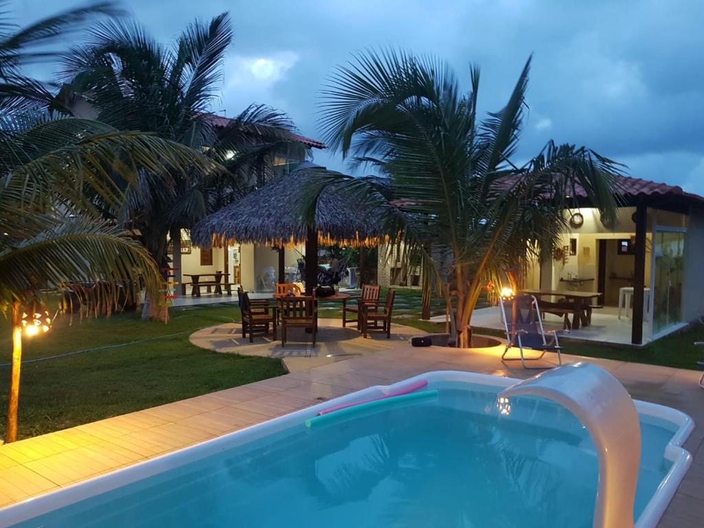 a swimming pool in front of a house at Rota do Mar in Luis Correia