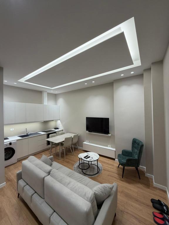 a living room with a couch and a flat screen tv at Apartment 27 in Elbasan