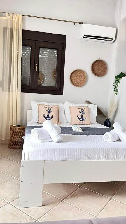 a white bedroom with two beds in a room at Sweet Studio in Leptokarya