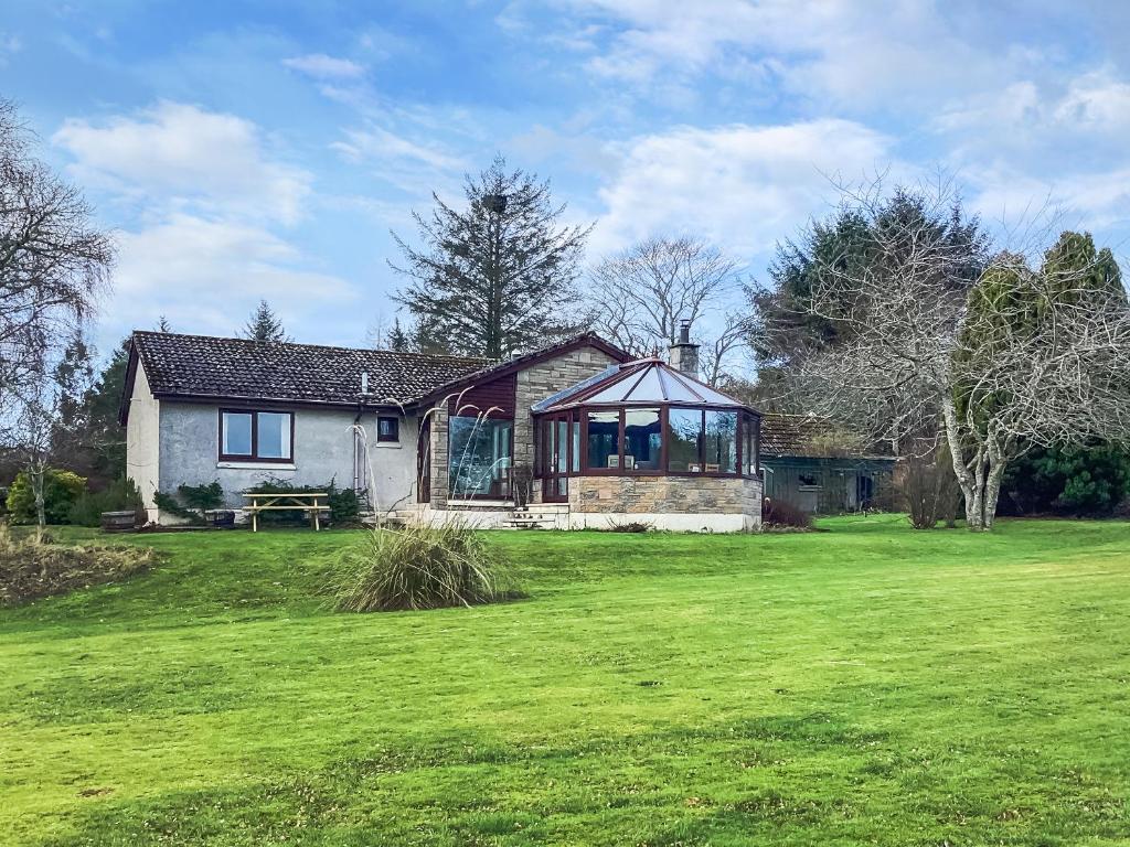 a house in a field with a green yard at Stroma in Edderton