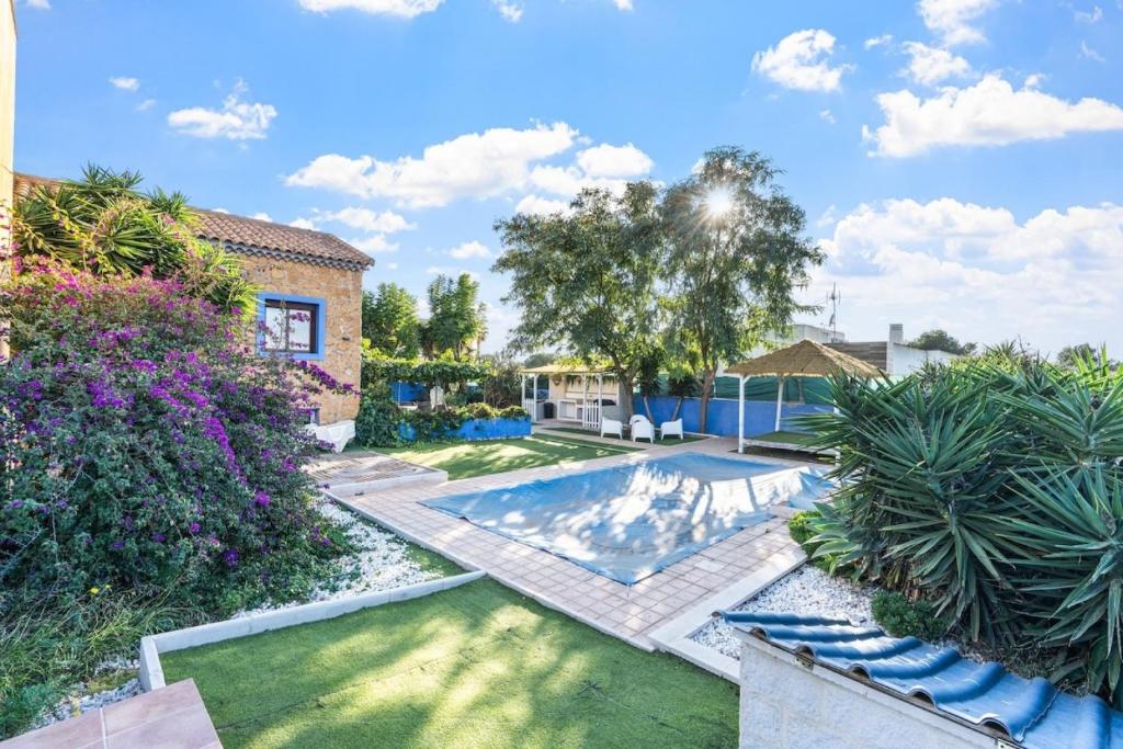 a backyard with a swimming pool and a house at Ca Marga in Santa Pola