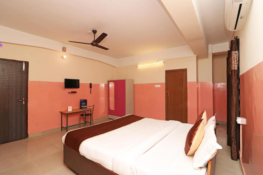 a bedroom with a bed and a ceiling fan at Hotel O Prabha Palace Lodge in Guwahati
