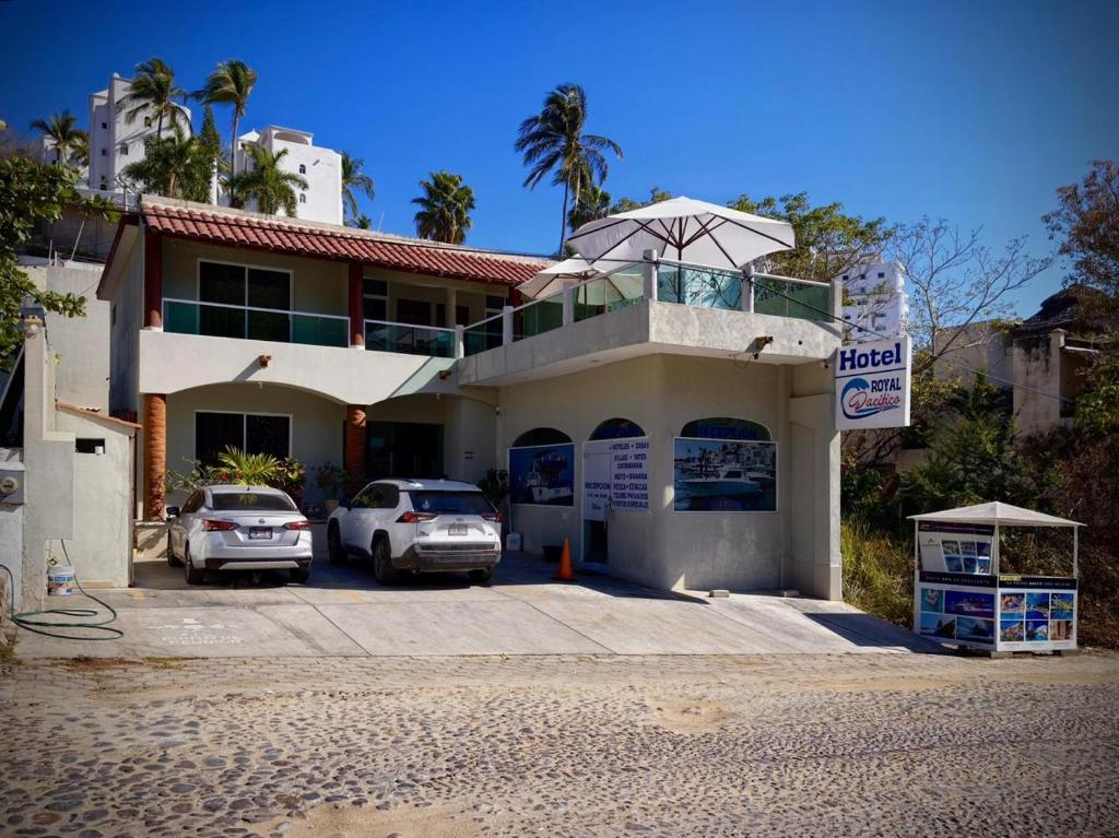 a building with two cars parked in a parking lot at Royal Pacífico Manzanillo in Manzanillo