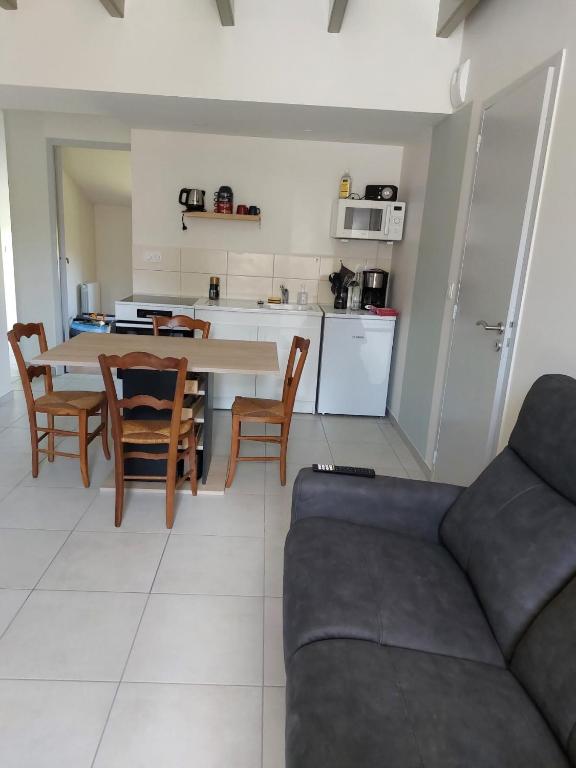 a living room with a couch and a table and chairs at Gîte La Caillère in Moncoutant