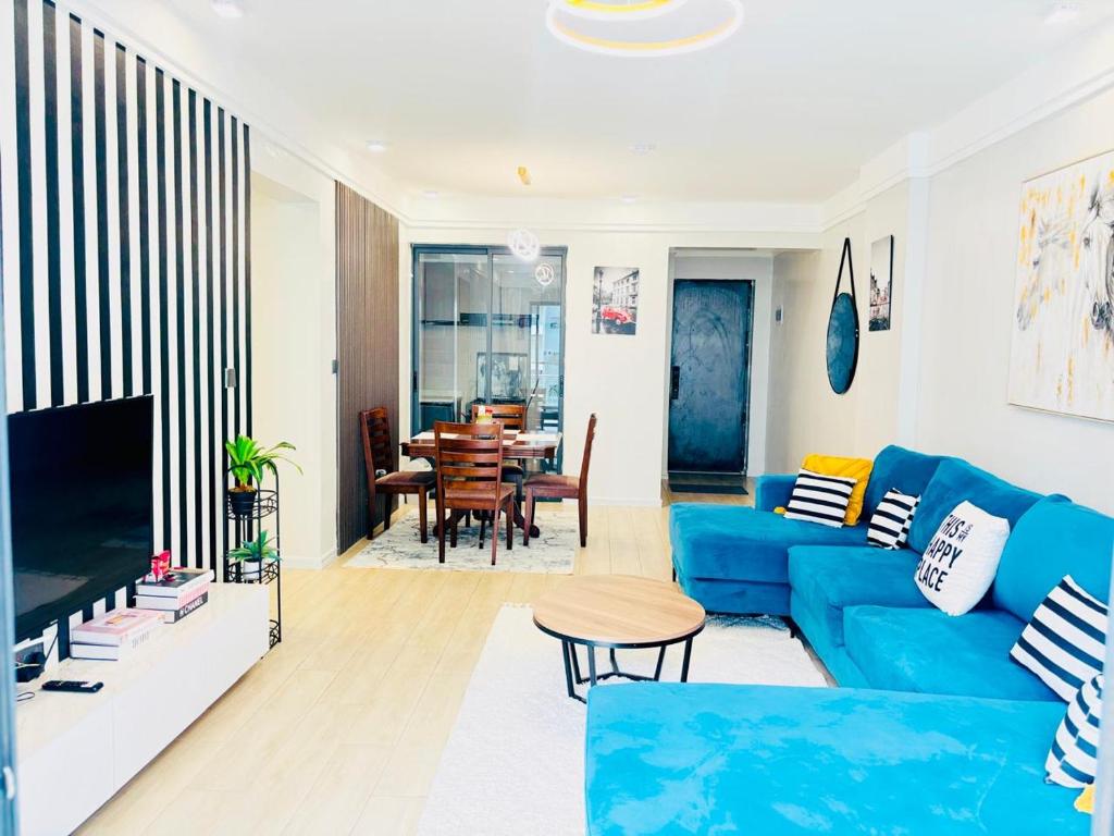 a living room with a blue couch and a table at Urban Homes-Two Bedroom Near JKIA Airport in Nairobi