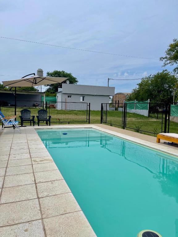 a large swimming pool with a fence and an umbrella at Complejo Juan Pablo in Colón