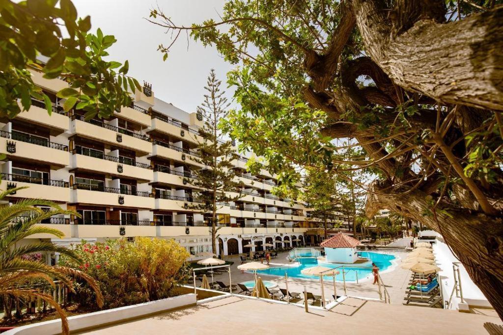 a hotel with tables and chairs and a building at BLUESEA Rey Carlos in Playa del Ingles