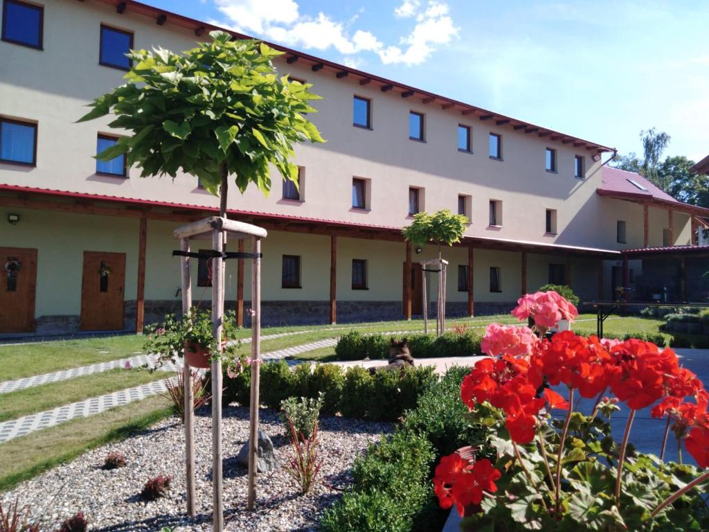 a building with red flowers in front of it at Bendovský dvůr in Dušníky