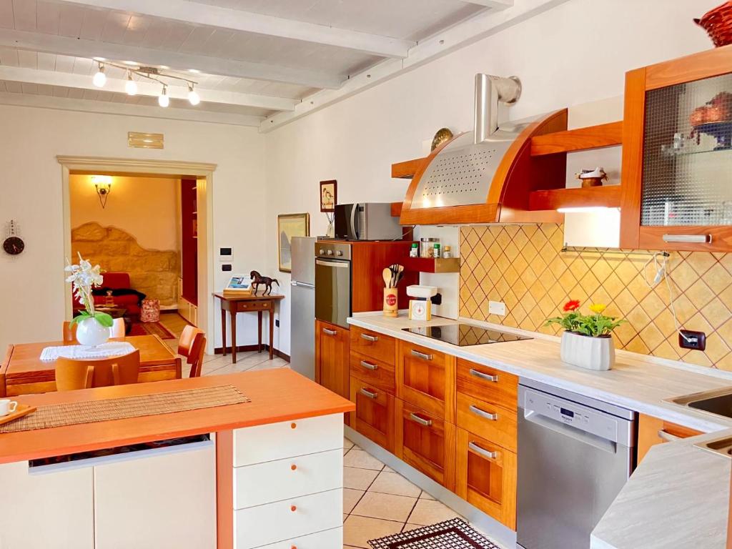 a kitchen with wooden cabinets and a counter top at Splendido appartamento tra mare e storia in Sorso
