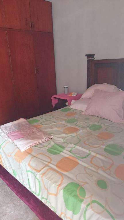 a large bed with a colorful blanket on it at Esperanza in Asunción