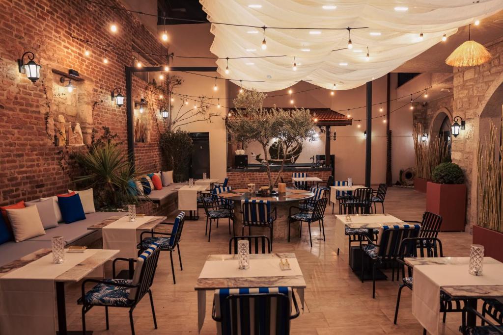 a restaurant with tables and chairs and a brick wall at Atrium Suites Taş Konak in Urla