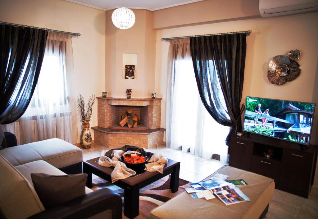 a living room with a couch and a fireplace at Agria Lux Apartment - Pelion - Volos in Agria