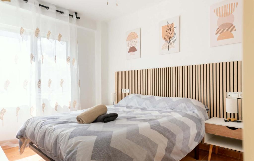 a white bedroom with a bed with a large window at Apartamento ROMA in Torre del Mar