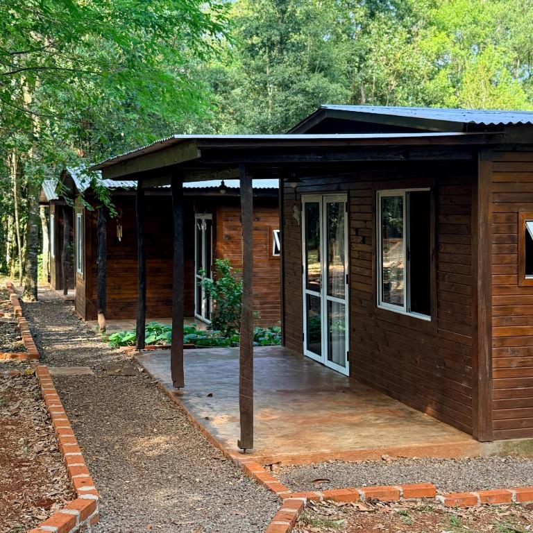 a wooden cabin with a porch in the woods at Cabañas Bruma de Monte in El Soberbio