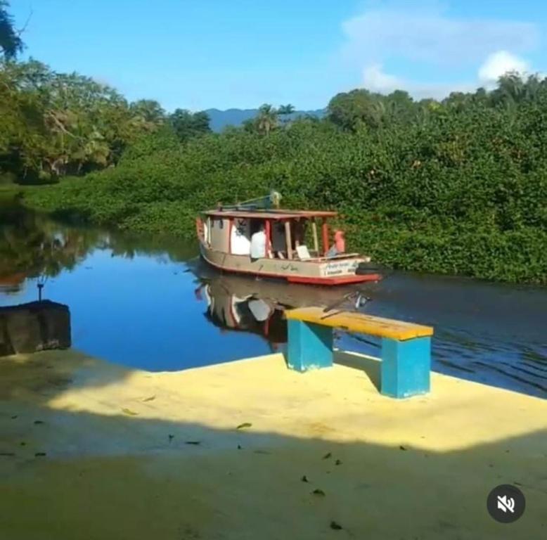 a boat on a river next to a dock at Pousada TURI in Caraguatatuba