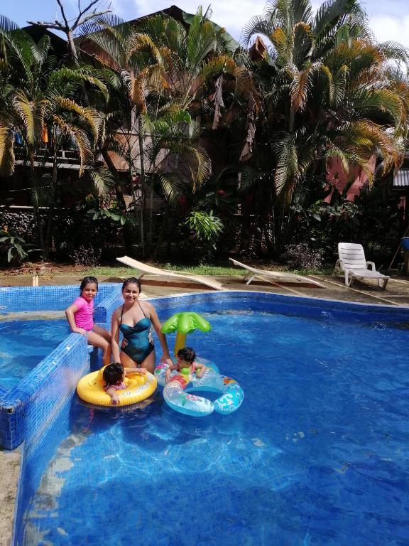 a woman and two children in a swimming pool at Casitas Joanna in Puerto Viejo