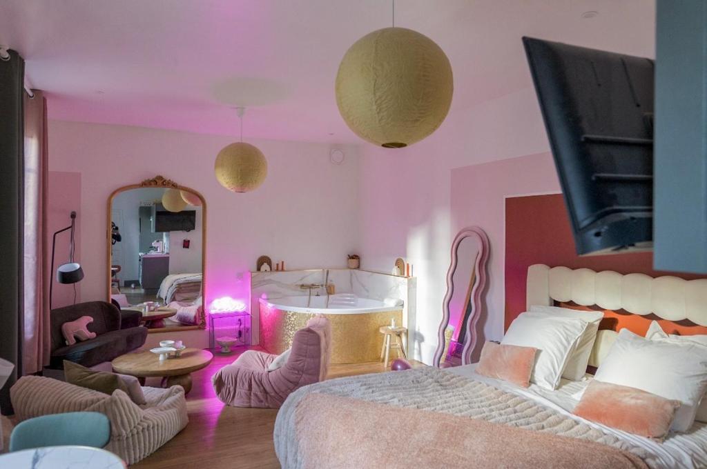a bedroom with a bed and a living room with pink walls at Mini loft Spa - Cosy in Dijon