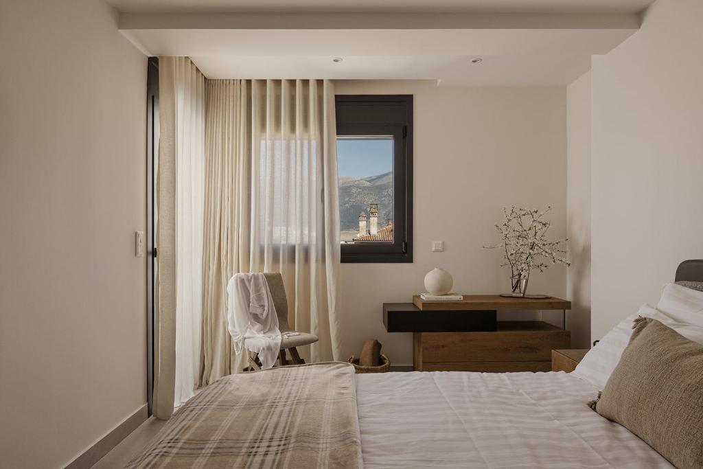 a bedroom with a bed and a chair and a window at Estia Urban Stay in Ioannina