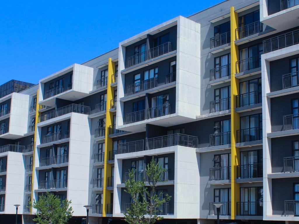 an apartment building with yellow columns at The Millennial, Secure parking, 3 mins to Gateway in Durban
