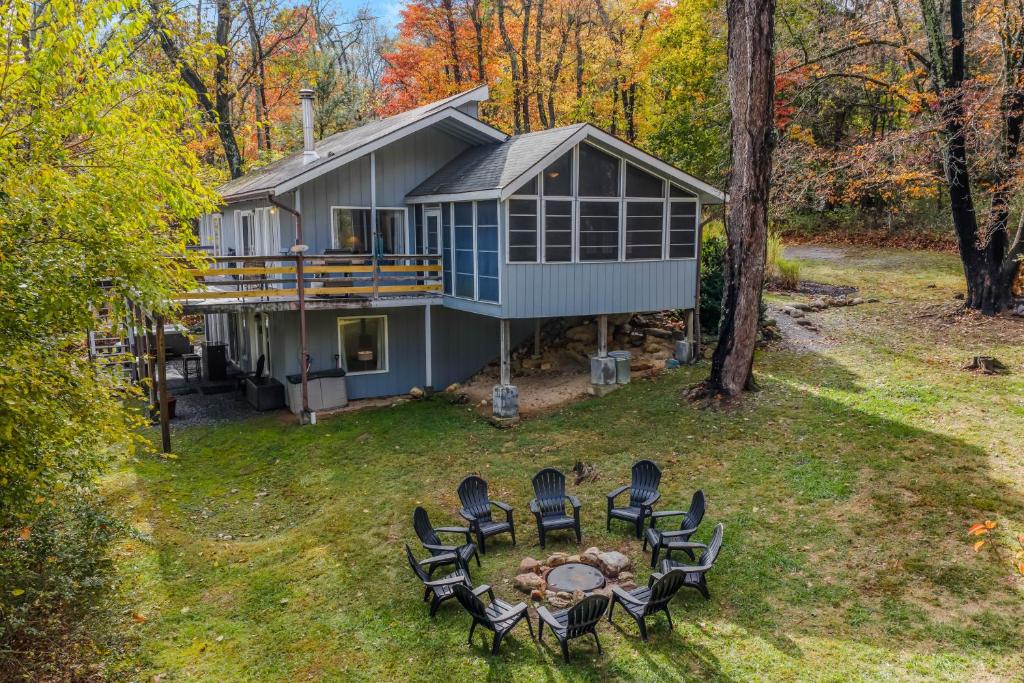 an aerial view of a house with chairs and a table at Serendipity -- Hot Tub - Pet Friendly - Fire Pit - Grill - Porch - Deck - Wifi - Pool Access - Games in Berkeley Springs