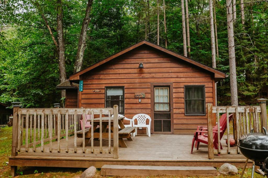 a cabin with a table and chairs on a wooden deck at Old Stoney's Walleye- Pet Friendly in Arbor Vitae