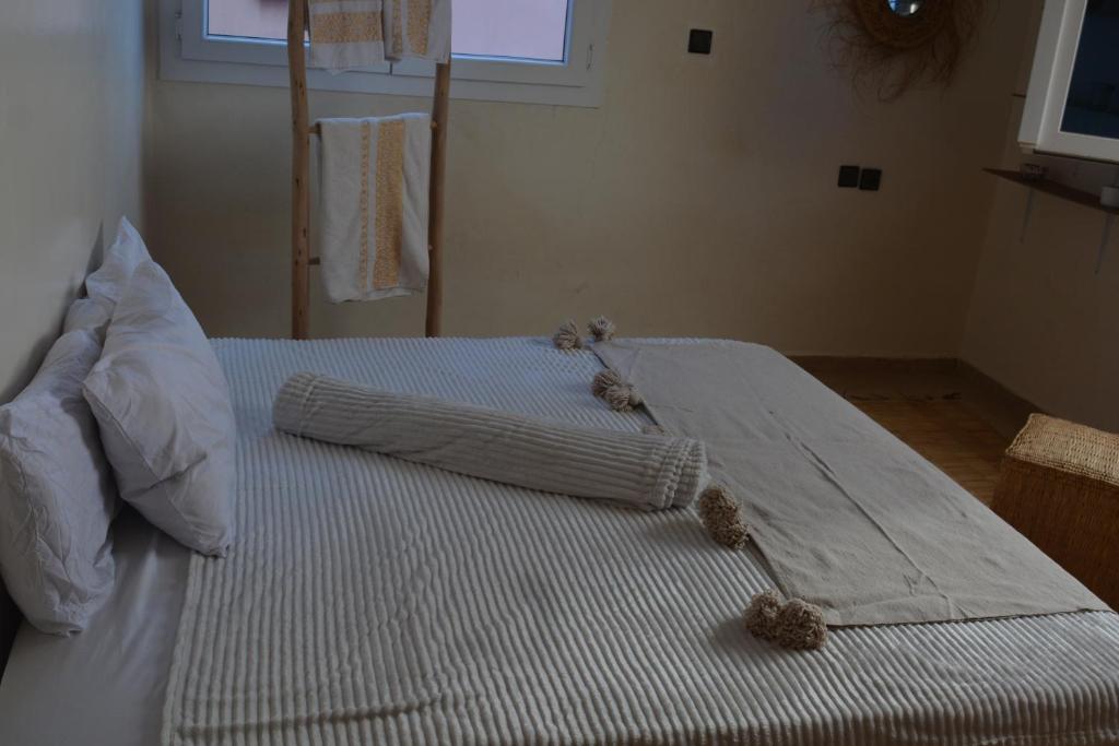 a white bed with two teddy bears sitting on it at west wave surf house in Tamraght Ouzdar
