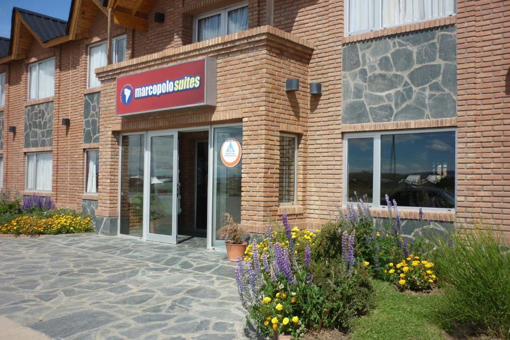 un bâtiment avec un panneau à l'avant dans l'établissement Marcopolo Suites Calafate, à El Calafate