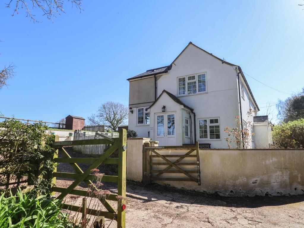 a white house with a gate and a fence at The Old Smithy in Bridport