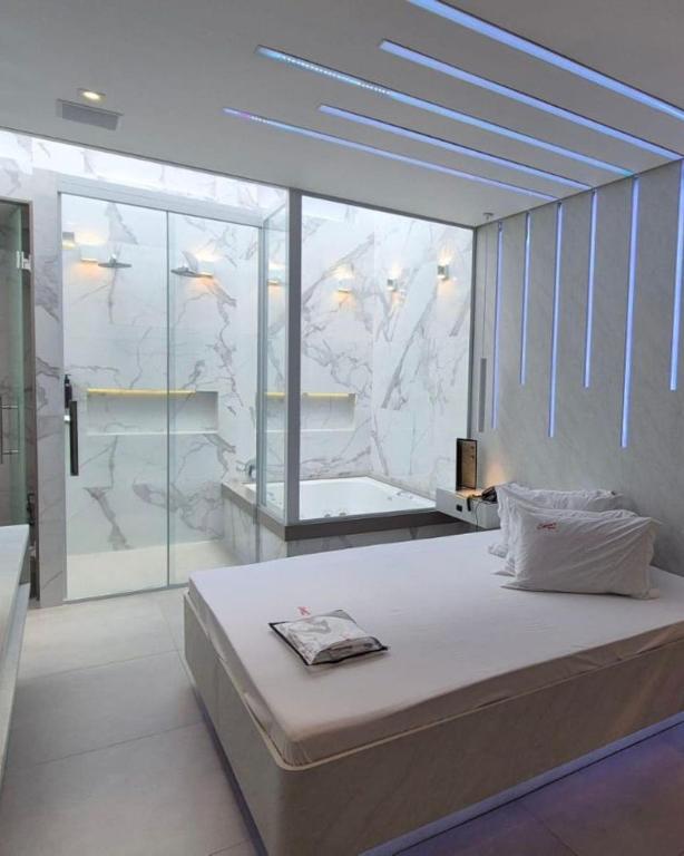 a bedroom with a large bed in front of a window at Motel Queens Aeroporto de Congonhas in São Paulo