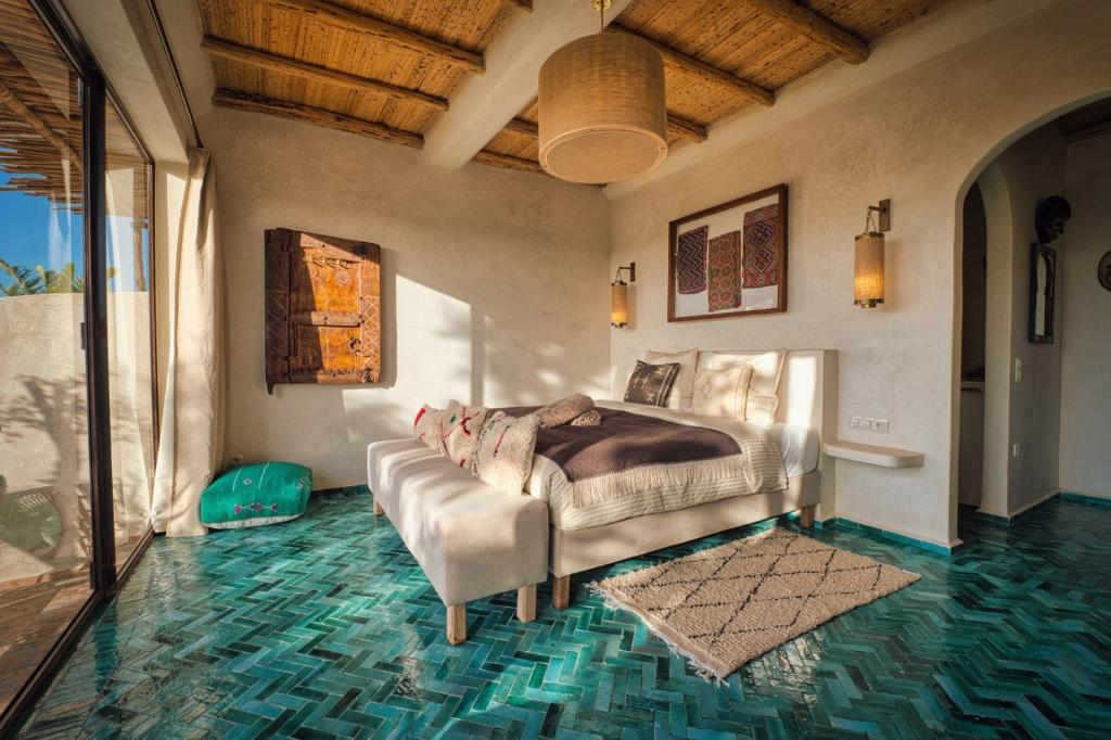 a bedroom with a bed and a glass floor at La Villa DUCASSE - Piscine, pétanque, calme à Essaouira in Essaouira