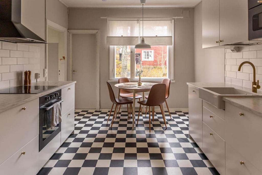 a kitchen with a table and chairs on a checkered floor at Seafront Country house with jacuzzi in Salo