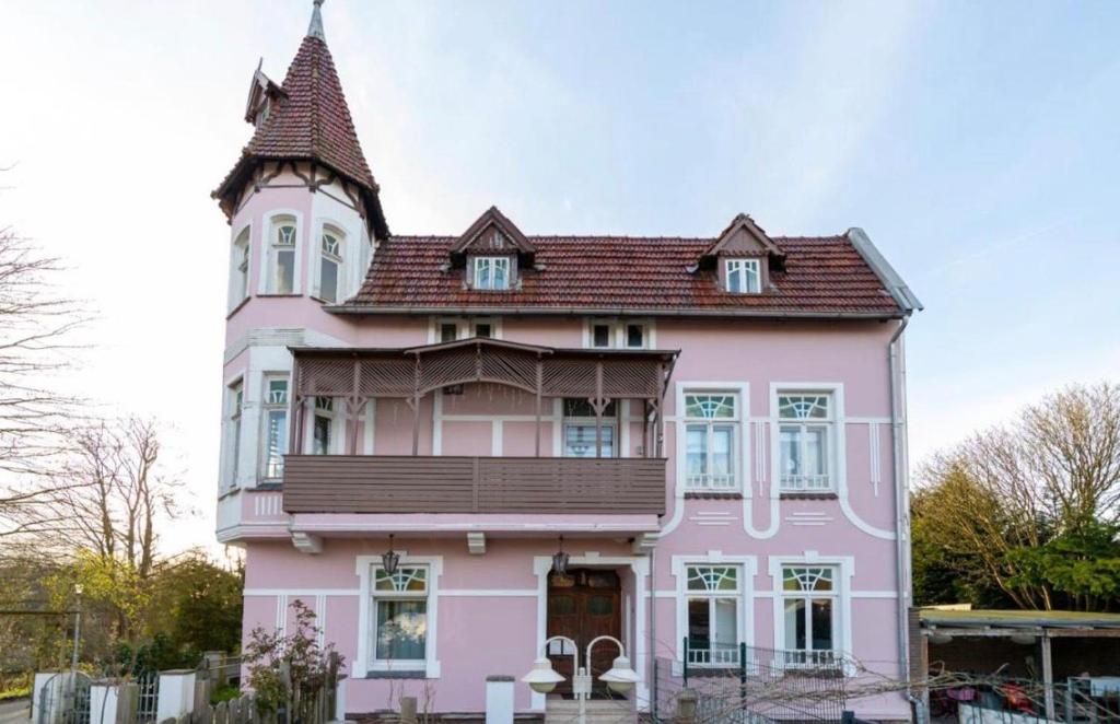 a pink house with a tower on top of it at RosaVilla in Wilhelmshaven