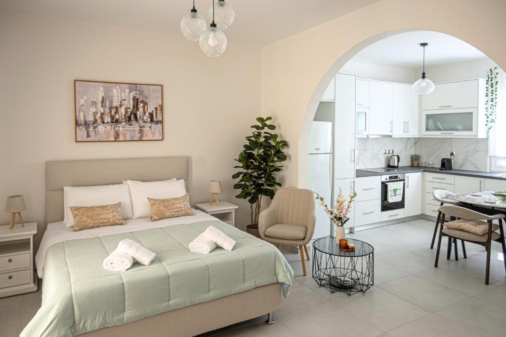 a bedroom with a large bed and a kitchen at Noméa - Modern Apartment Aigio in Aigio