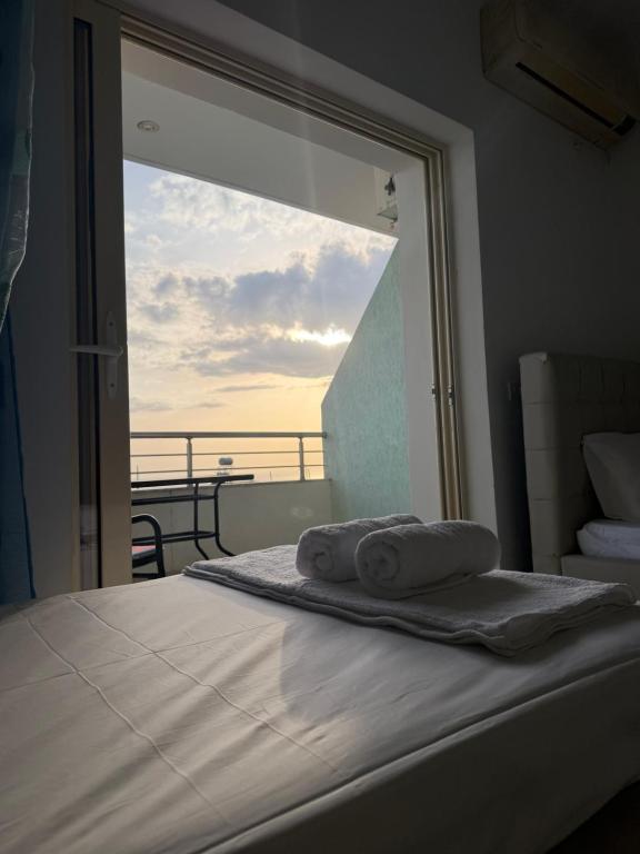 a bedroom with a bed with a view of the ocean at Dhermi Light Rooms in Dhërmi
