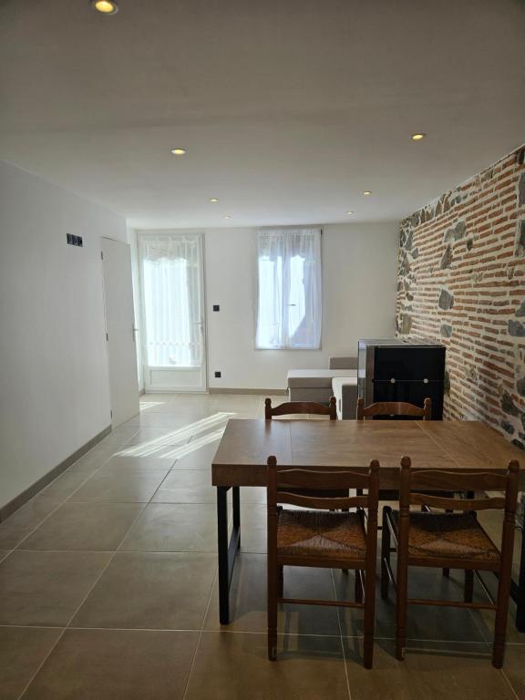 a dining room with a wooden table and chairs at Petite maison design proche centre ville in Cusset