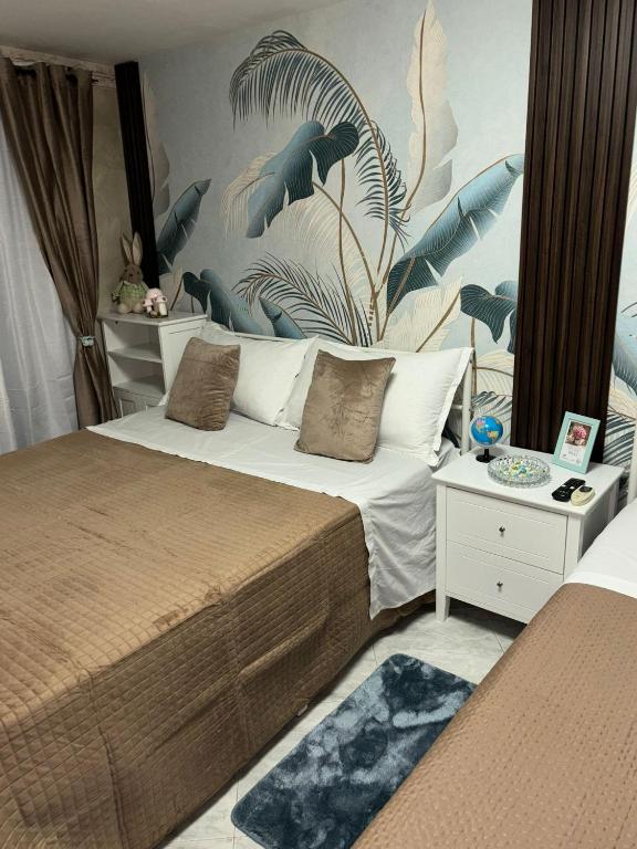 a bedroom with two beds and a wall with plants at Casa Concettina in Naples