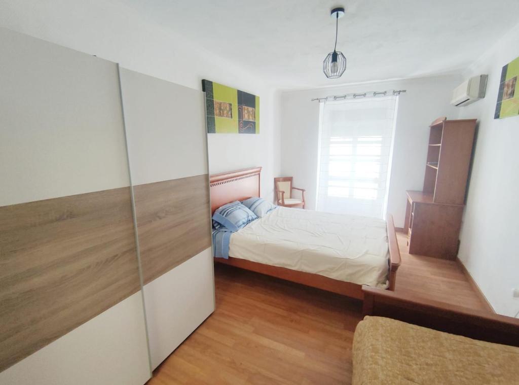 a bedroom with a bed and a sliding glass door at Mouraria in Elvas