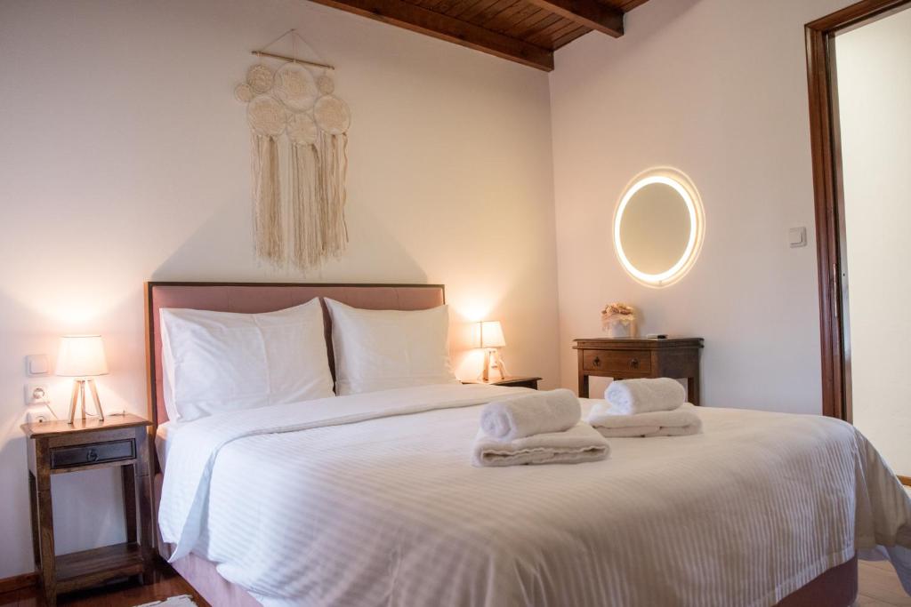 a bedroom with a white bed with towels on it at Hope Nest Pelion in Zagora
