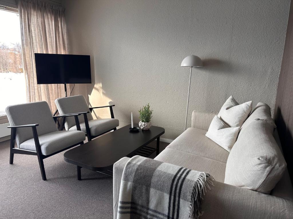 a living room with a couch and two chairs and a table at Leilighet på Hovden in Bykle