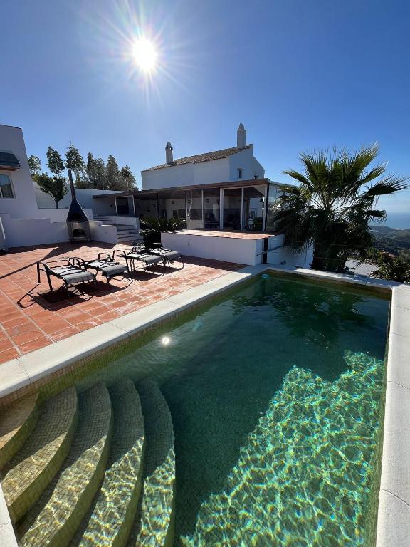 a large swimming pool in front of a house at Casa La Jolla B&B in Cómpeta