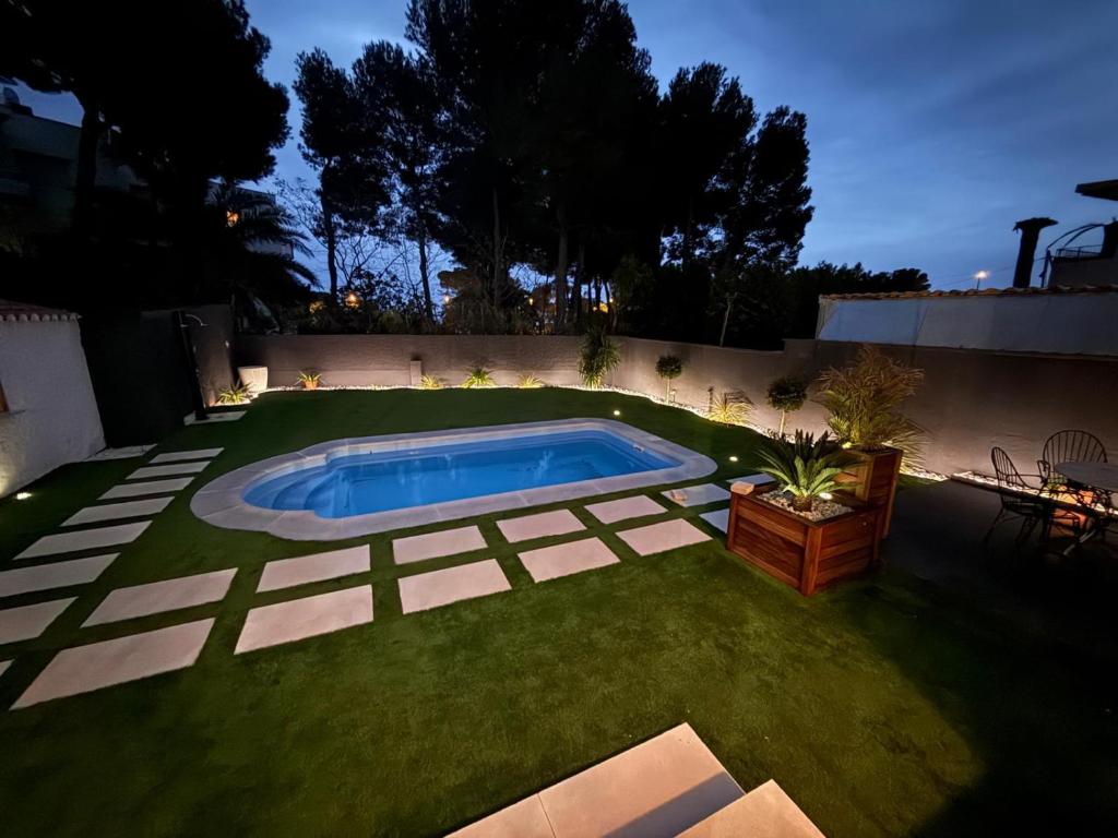 a backyard with a swimming pool and grass at Evian Cala in Miami Platja