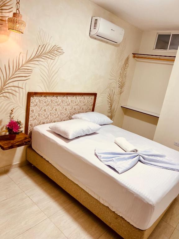 a bed with two towels on it in a room at Aparta hotel brisas Del tayrona in Santa Marta
