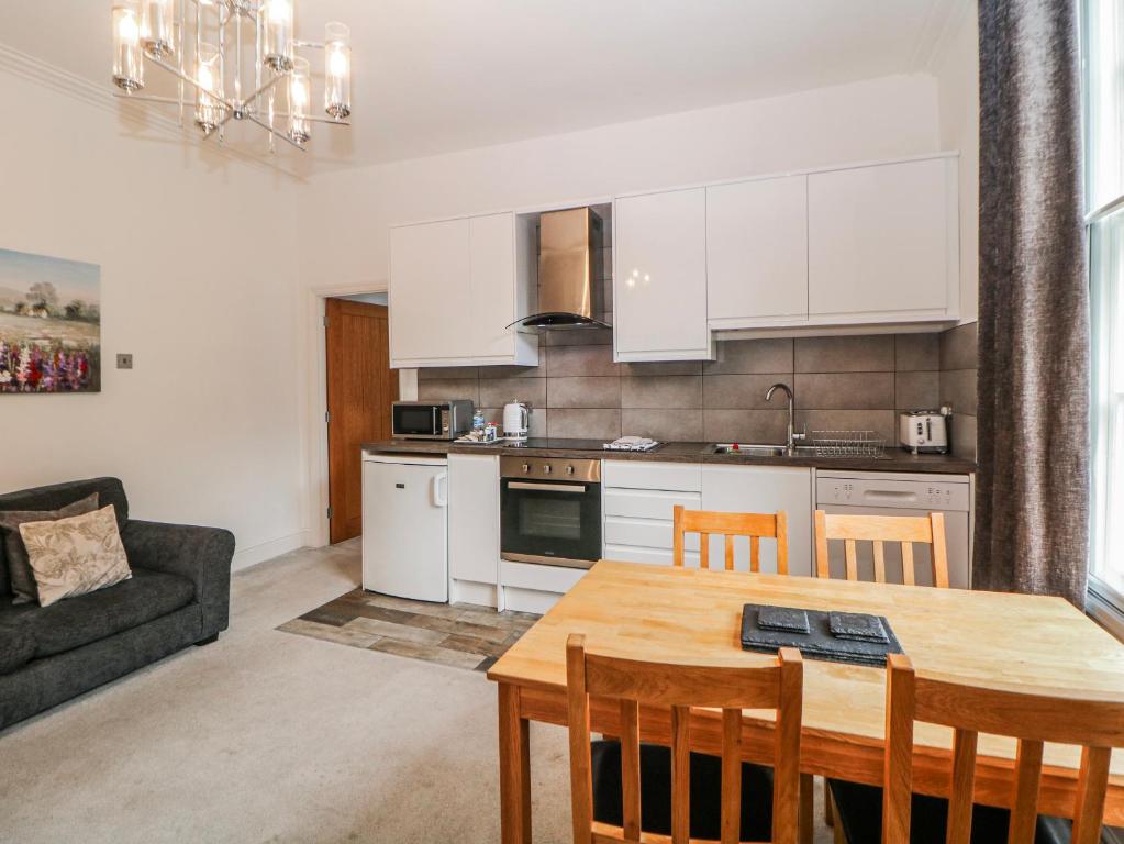 a kitchen and living room with a table and a couch at Gulliver's in Matlock