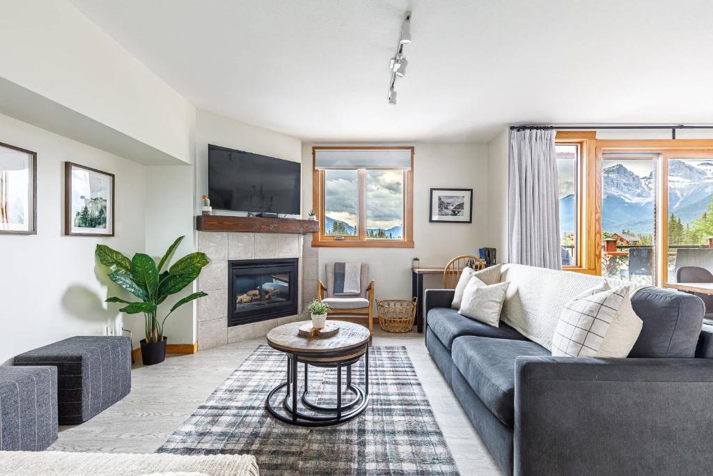 a living room with a couch and a fireplace at Morningside - Pet Friendly Stunning Mtn Views in Canmore